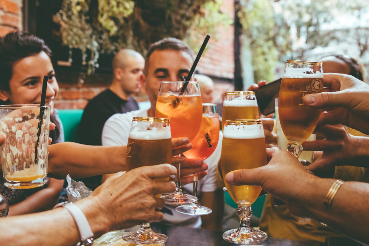 Trois personnes avec des verres en conversation dans un bar