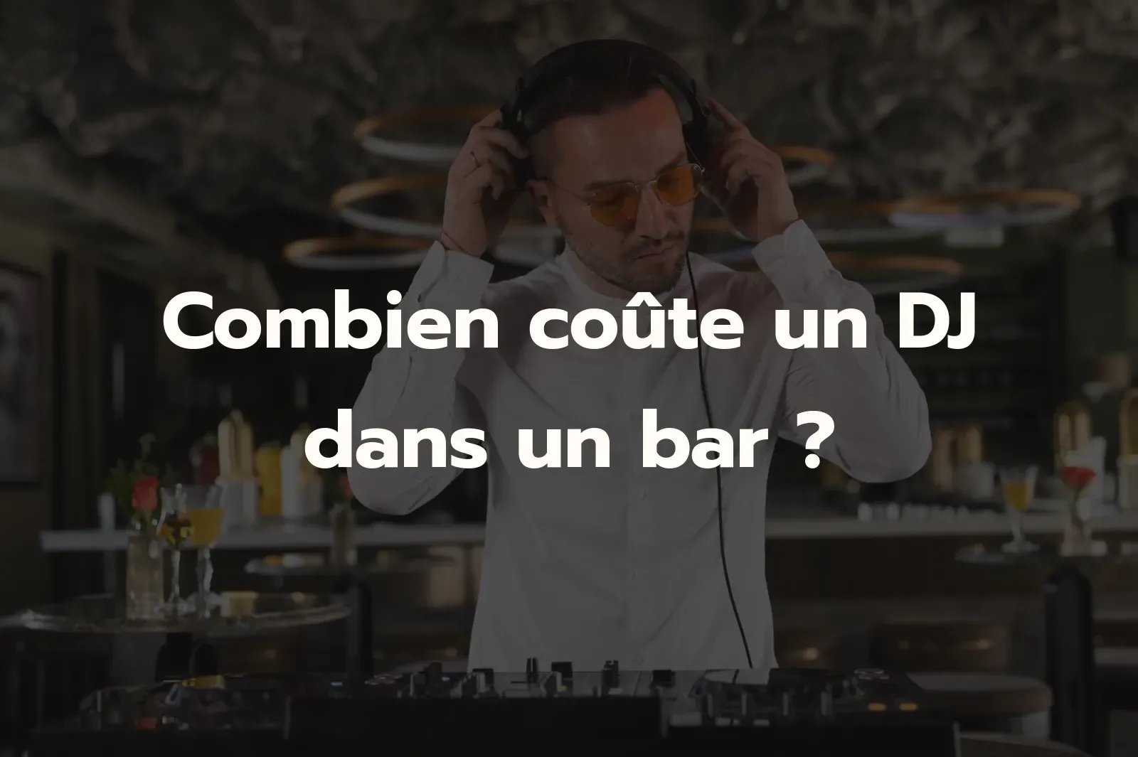 Combien coûte un DJ dans un bar ? DJ casque sur les oreilles derrière ses platines dans un bar à cocktails